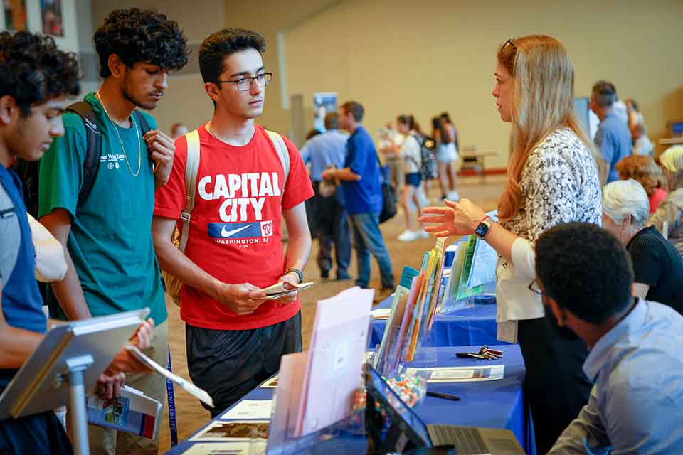 Students speak to an academic staff member during a SLU academic fair.