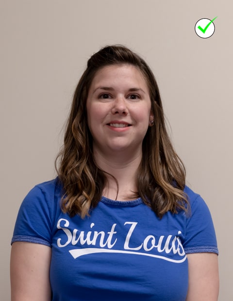 A headshot of a woman wearing a SLU t-shirt. The photo is well-lit and the woman is centered in the frame and is smiling naturally at the camera.