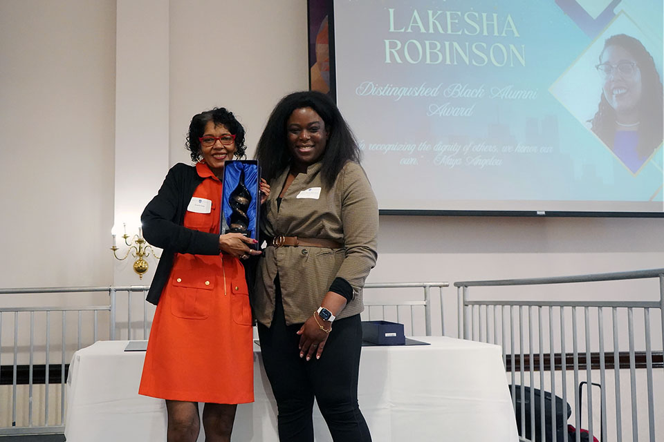 BAA Distinguished Black Alumni Award 2026 Lakesha Robinson's mother accepts an award on her behalf at an event on campus.