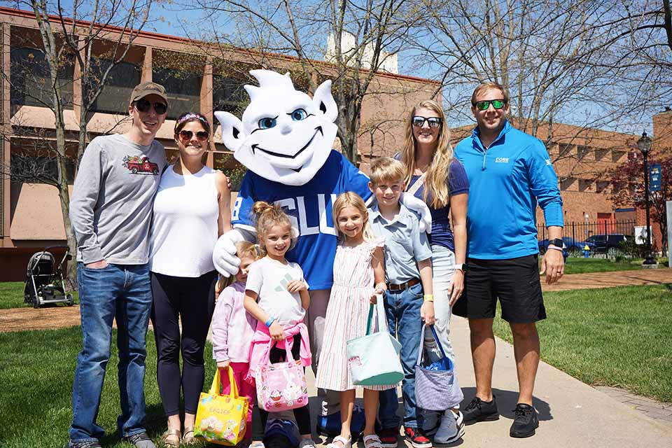 The Billiken poses for a photo with a SLU family during the annual Easter Egg Hunt.