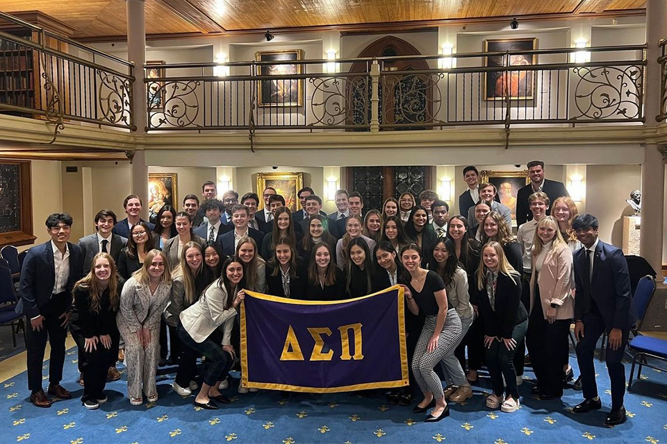Delta Sigma Pi Members of the Delta Sigma Pi business fraternity pose for a class photo around their fraternity flag in the Marquette gallery