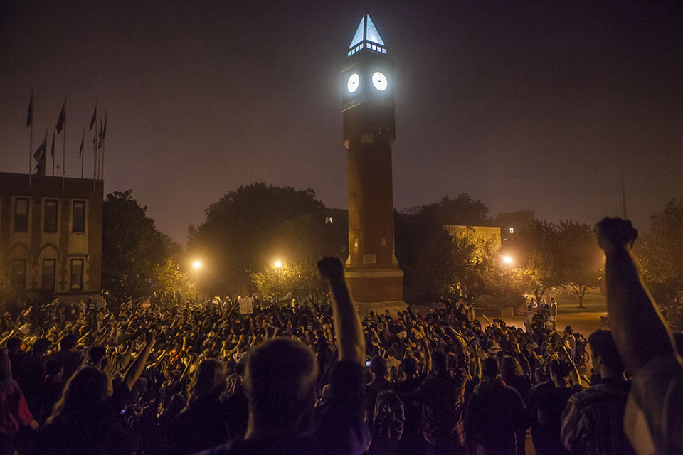 Clock tower The SLU Clock Tower is lit up at night while surrounded by students with fists raised in the air.