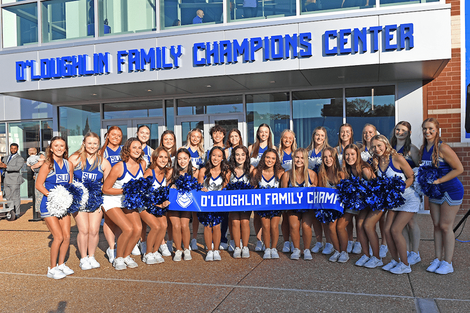 Cheerleaders O'loughlin Center A group of cheerleaders pose for a photo with a banner that states o'loughlin family champions center