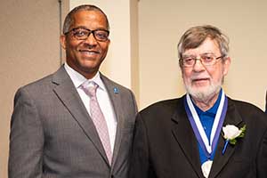 Frank Magiera poses for a photo with the School of Science and Engineering dean while wearing a medal.