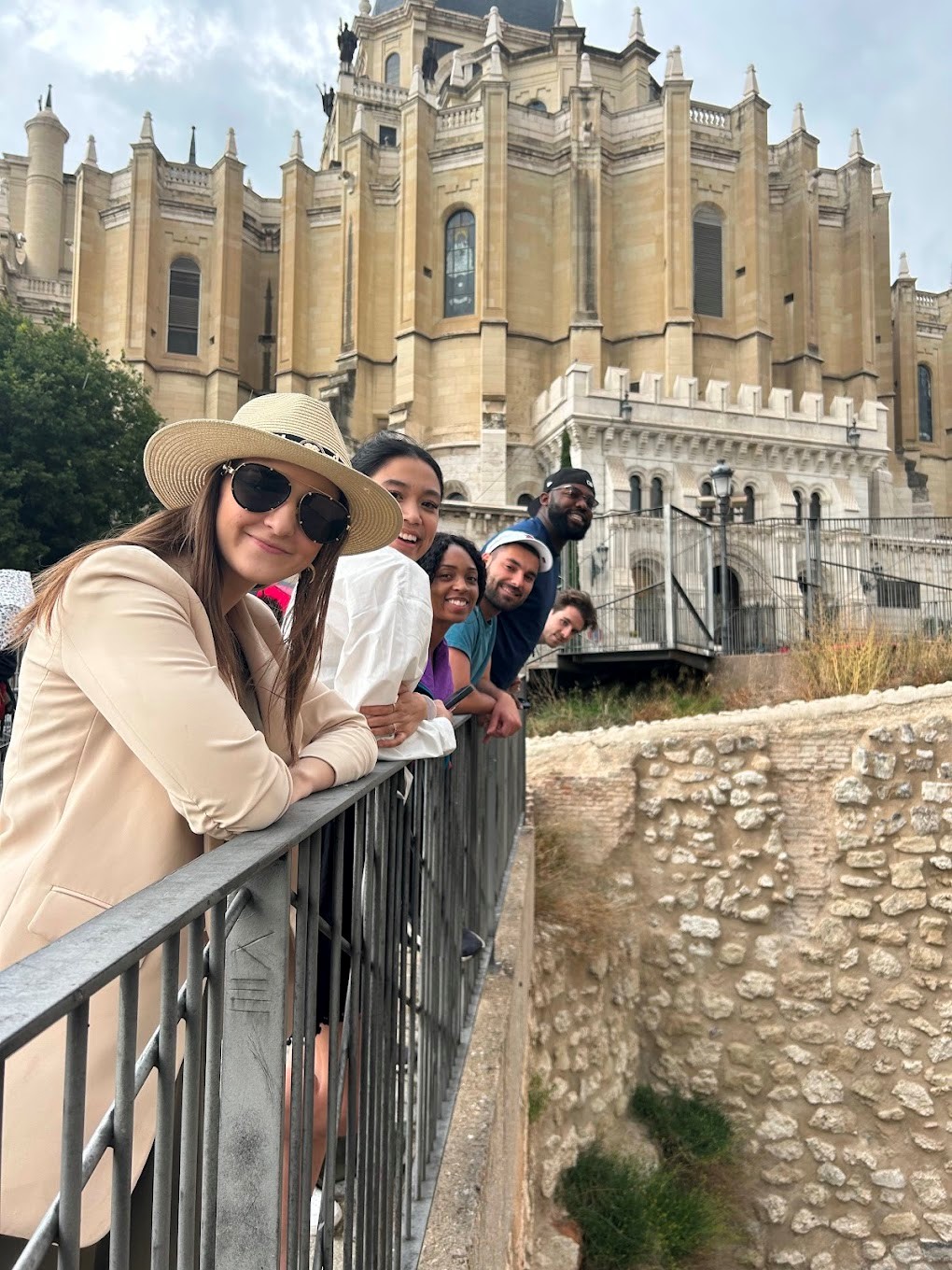 Students on a walking tour in Madrid Students look over the railing of a bridge in front of a historic building.