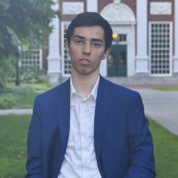 Ashkan Shafaei posing in front of a brick building.