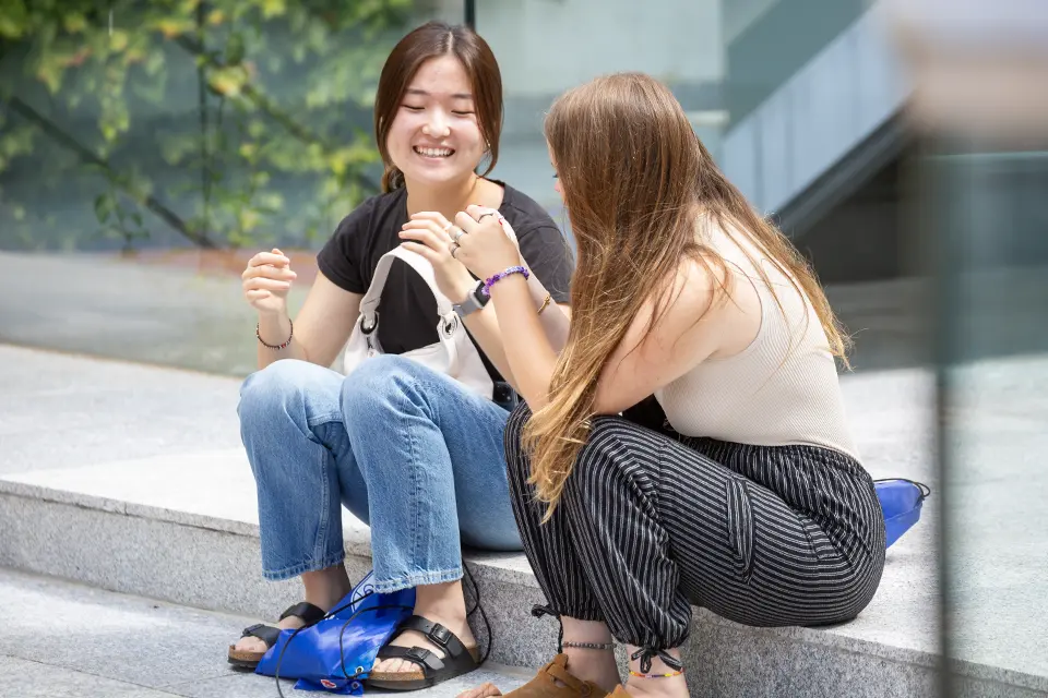 Academic Advising Two students talking while sitting at the PRH patio