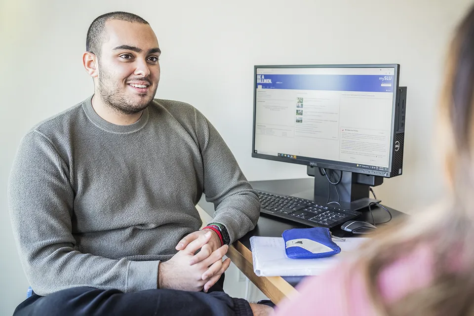 Online Degrees Two students with laptops at SIH patio