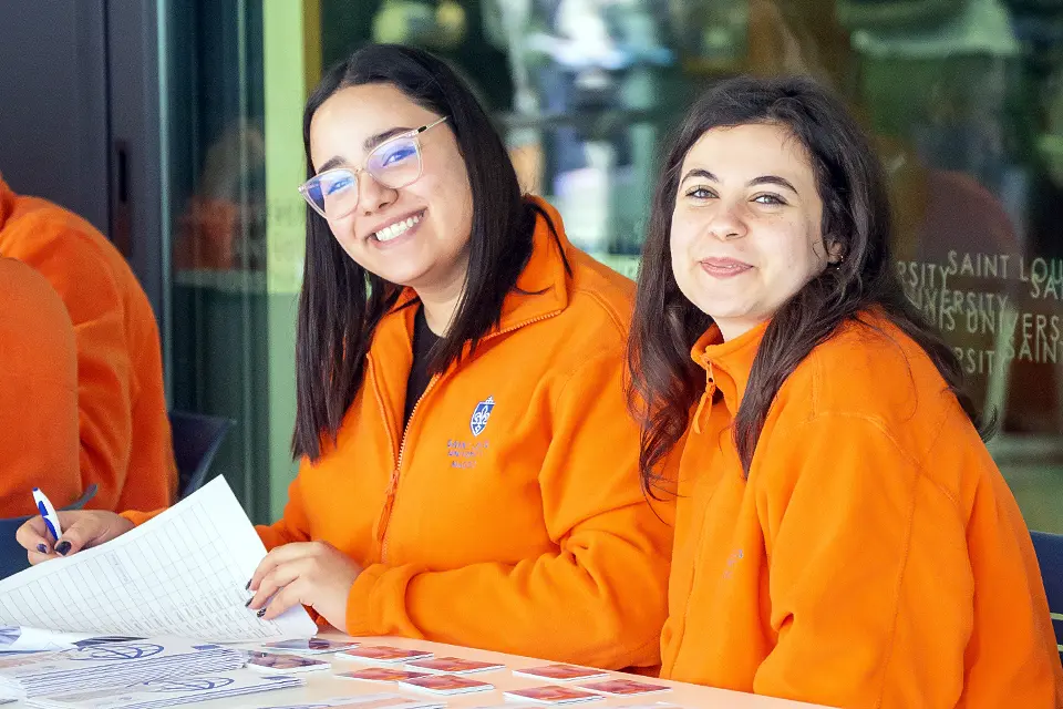 Two campus ambassadors pose for a photo outdoors on the SLU Madrid campus.