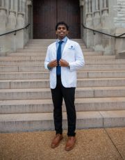Man posing in white coat Sabareesh Pitchumani Sundarraj posing outdoors in a white coat