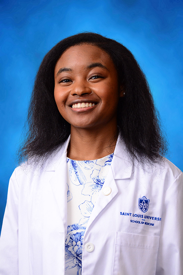 Ayanna Shambe Ayanna Shambe poses for a headshot in her white coat against a blue background.