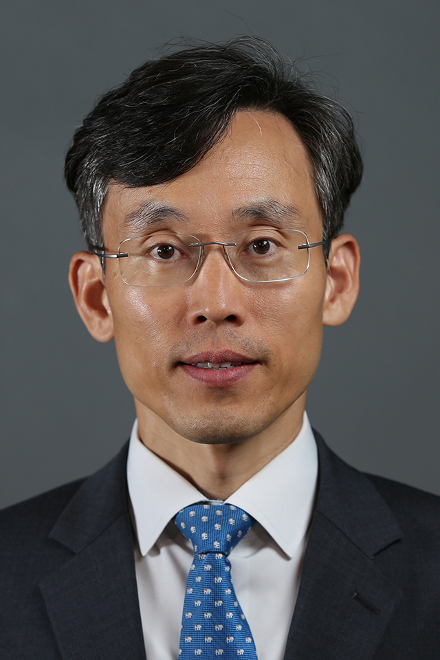 SangNam Ahn, Ph.D. A headshot of SangNam Ahn, Ph.D. He smiles for a photo against a gray background.