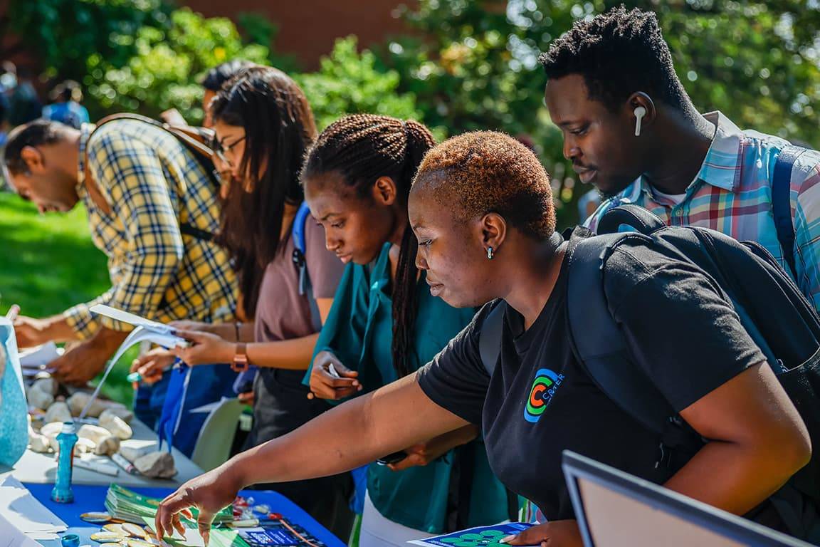 SLU community members browse mental health resources at an outdoor booth